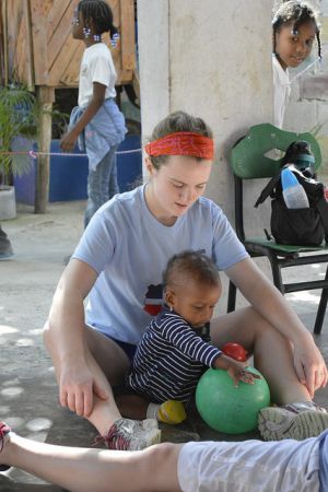 SMWC student Erin Harnett plays with a young child living in the Dominican Republic.