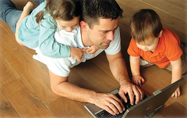 father with laptop and children