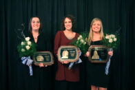 Erin, Stephanie and Jamie stand together holding their plaques at the Hall of Fame Banquet