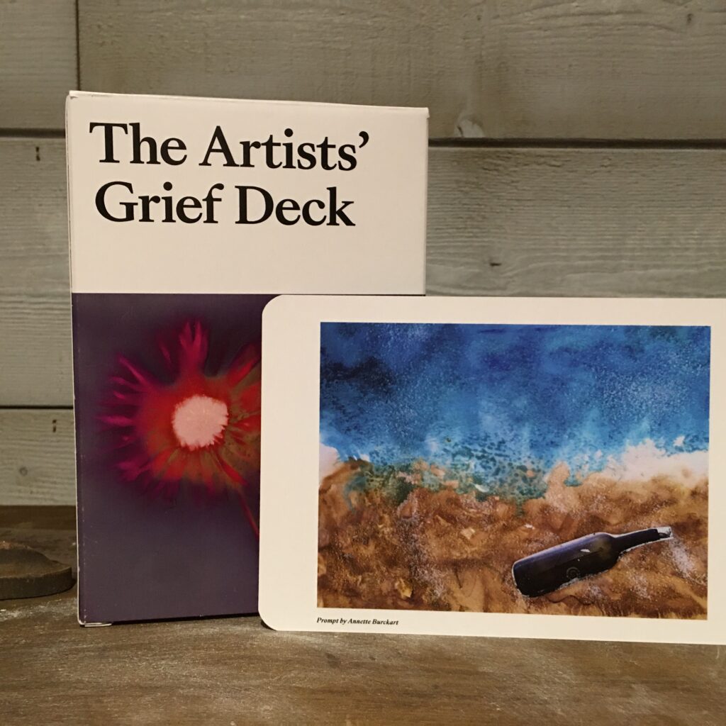 Photo of The Artists Grief Deck and the piece featured on a card