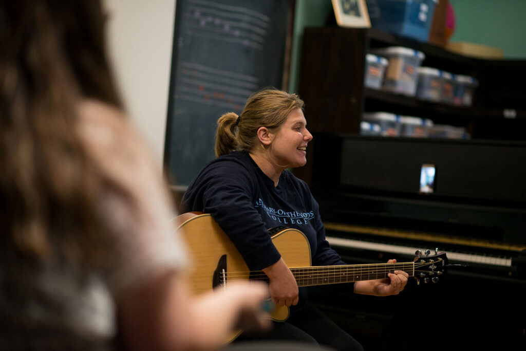 Student playing guitar in class