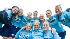 softball women huddle together